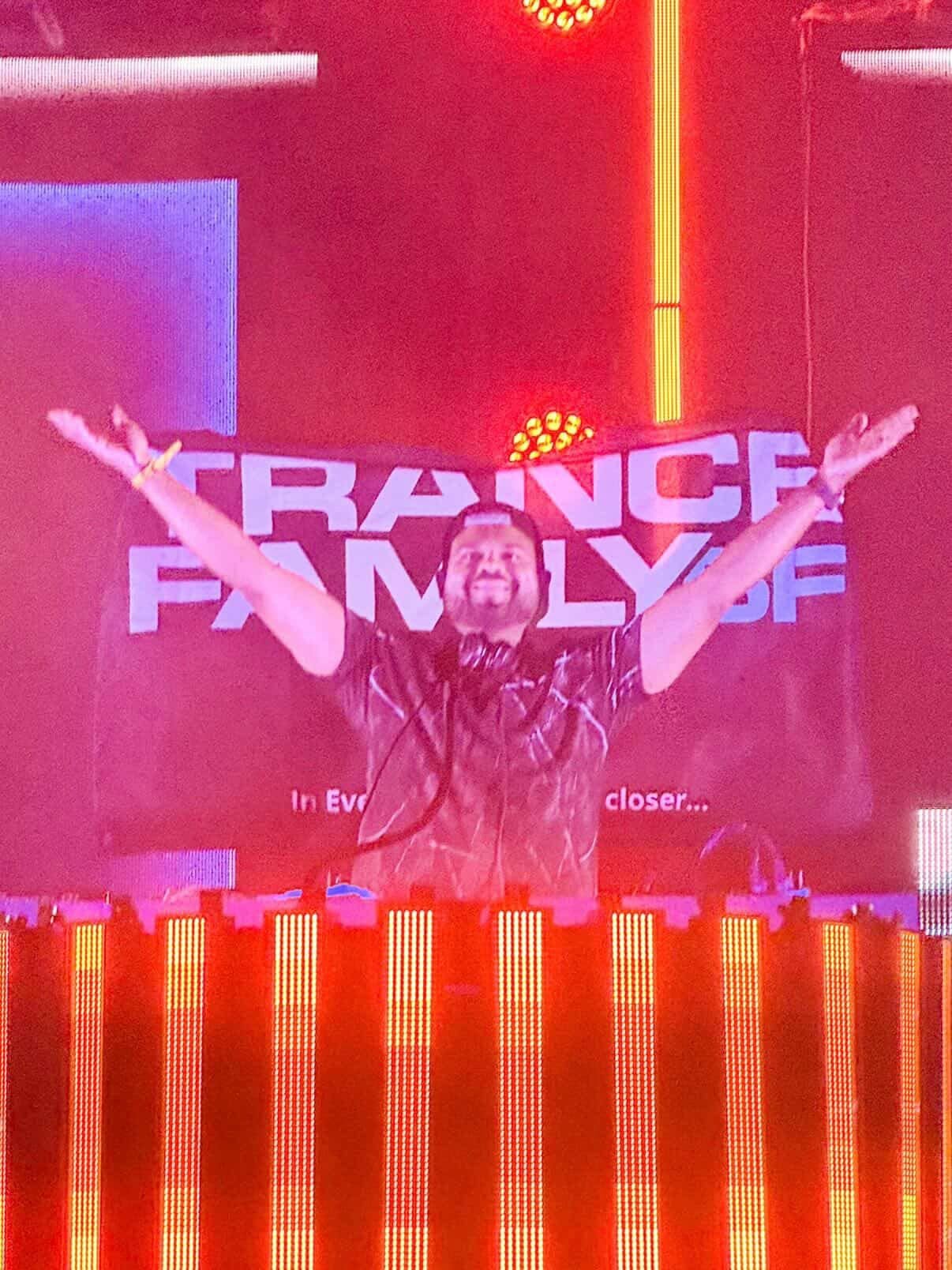 Sony Jacob celebrating with arms raised in front of the Trance Family SF sign